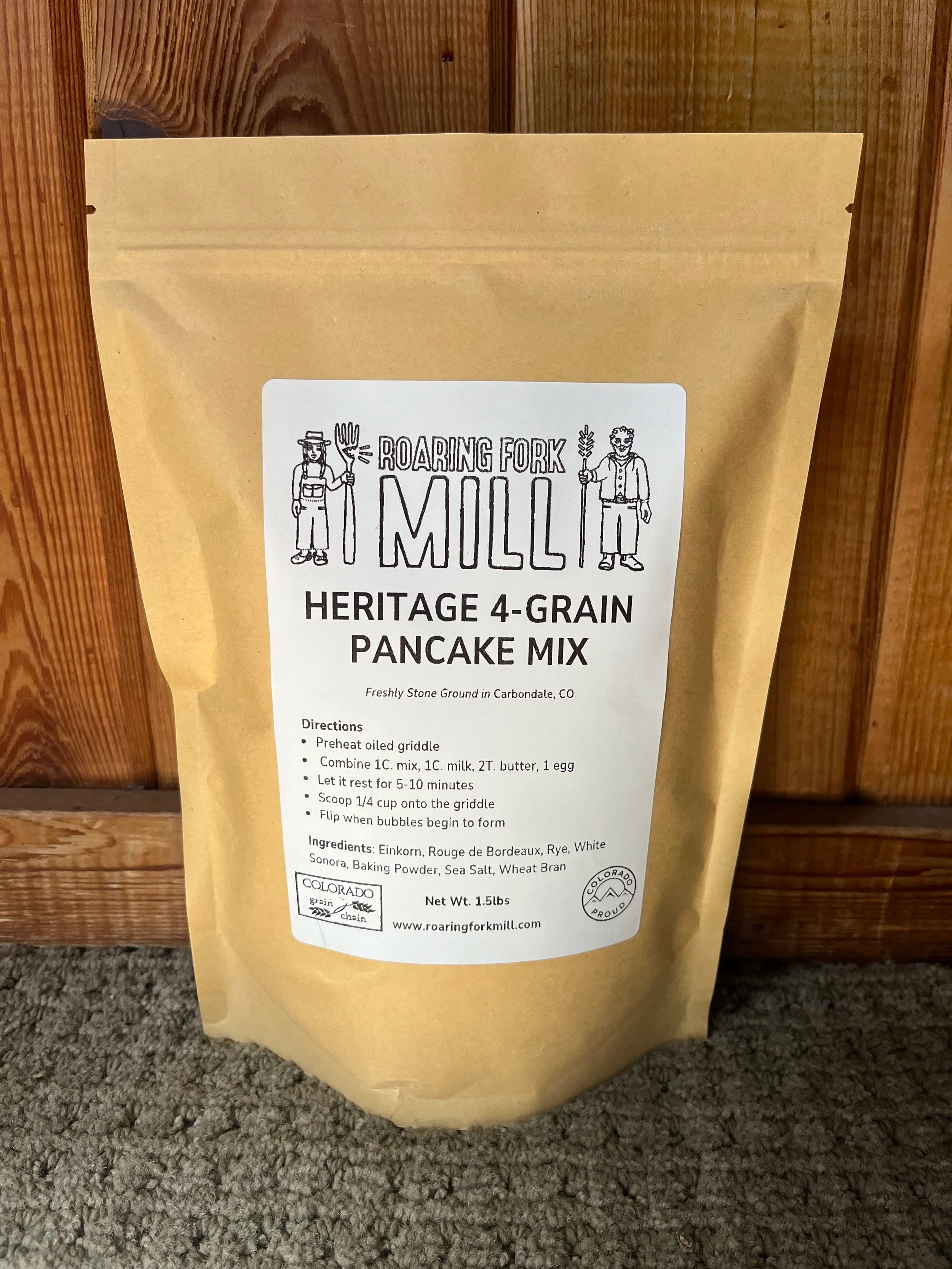 Bag of Heritage 4-Grain Pancake Mix from Roaring Fork Mill against a wooden background