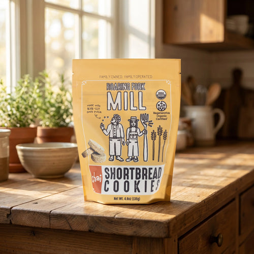 Packaging of Roaring Fork Mill Shortbread Cookies on a wooden table with a kitchen background