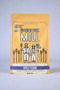 Package of Roaring Fork Mill spelt flour on a light gray background